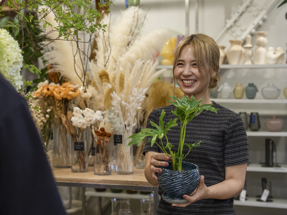 スタッフが植物を持って接客する様子